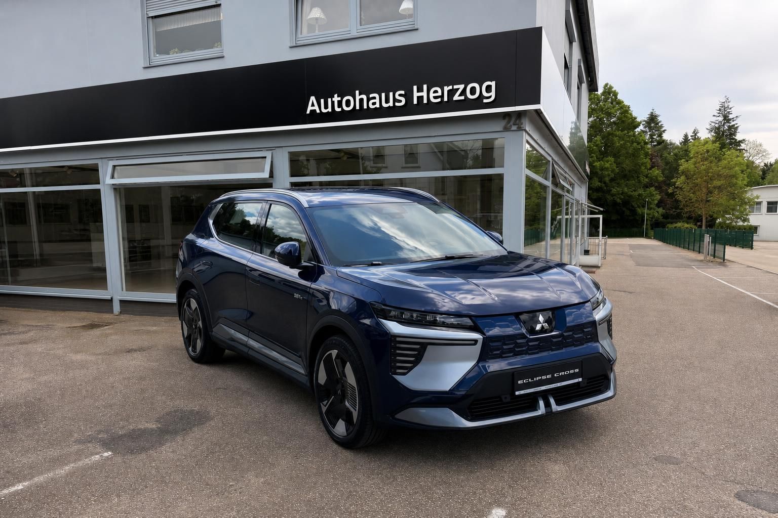 Blauer Mitsubishi Eclipse Cross SUV vor Autohaus Herzog - Frontansicht mit modernem LED-Design