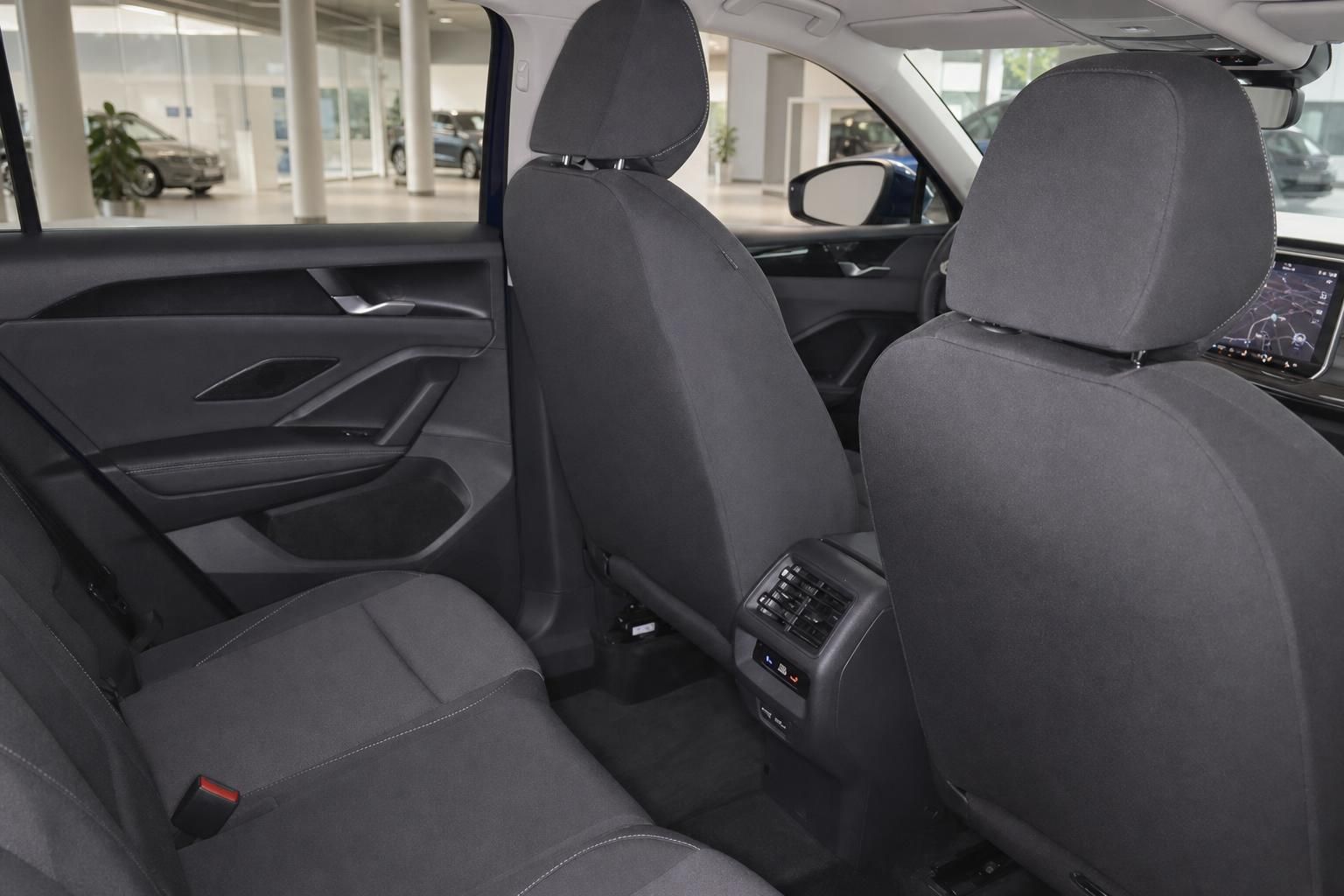 Blick auf Rücksitze und Vordersitze im Fahrzeuginnenraum mit Navigationsdisplay
