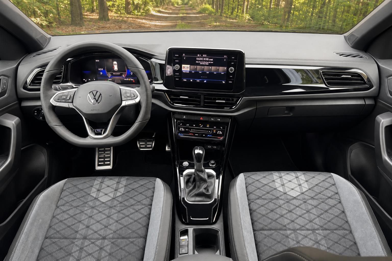 Volkswagen Innenraum mit Cockpit, Lenkrad, Touchscreen und karierter Sitzpolsterung