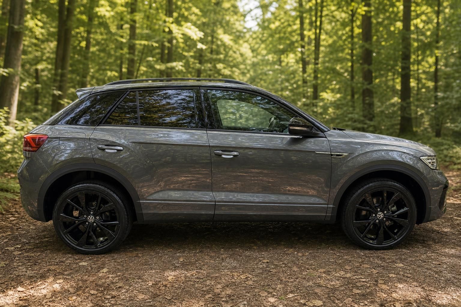 VW T-Roc Seitenansicht grau metallic mit schwarzen Rädern - Kompakt-SUV im Wald