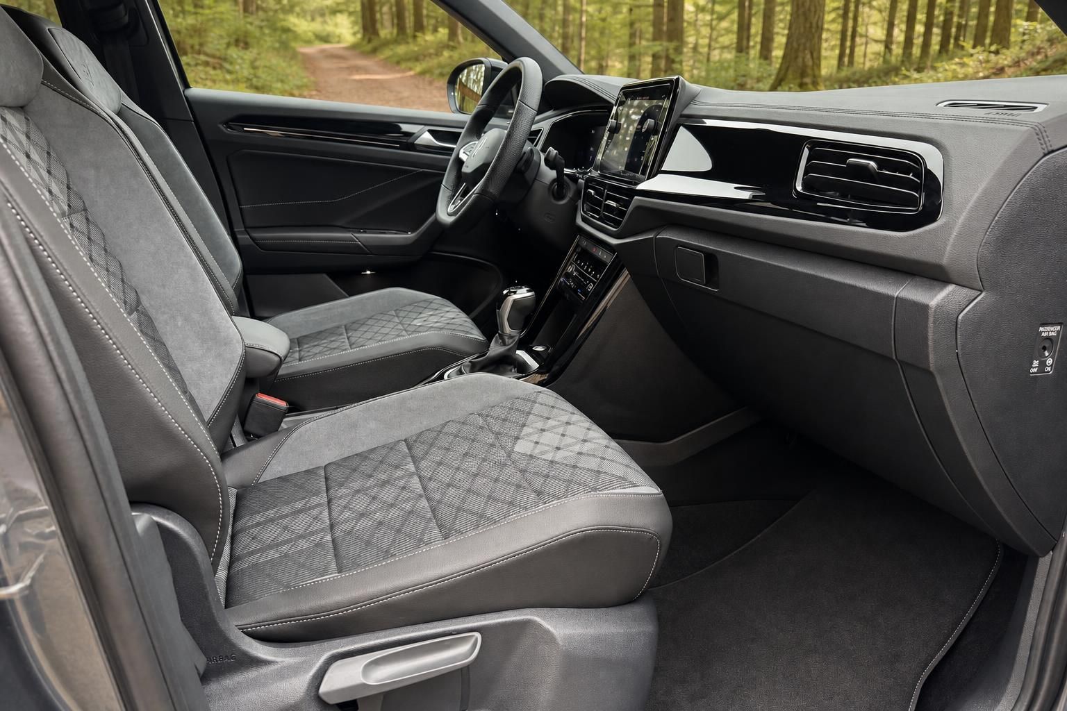 Innenraum eines Volkswagen T-Roc mit grauen Sportsitzen, Infotainment-Display und Multifunktionslenkrad