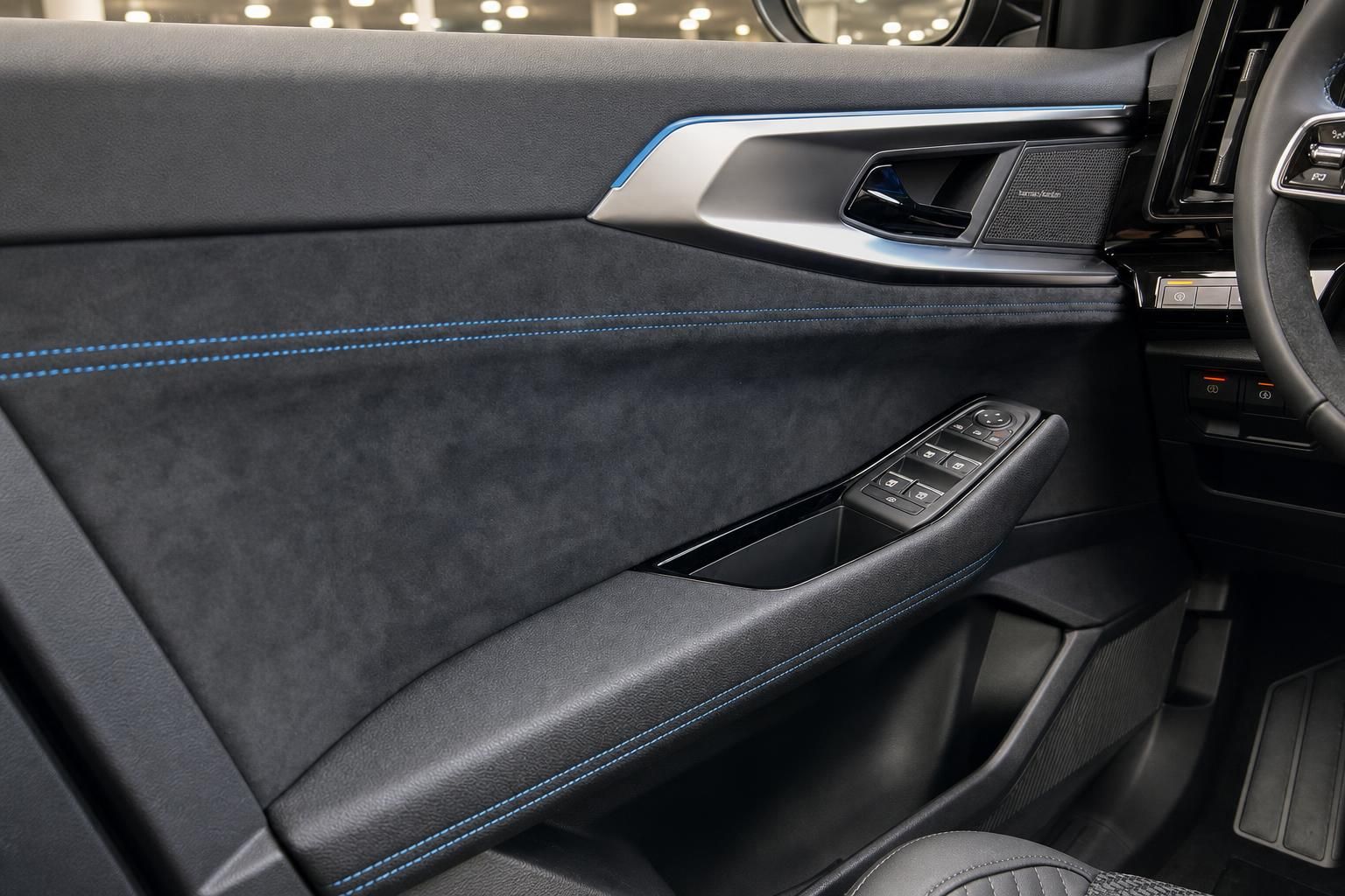 Türverkleidung mit blauer Ziernaht und Bedienelementen im Interieur