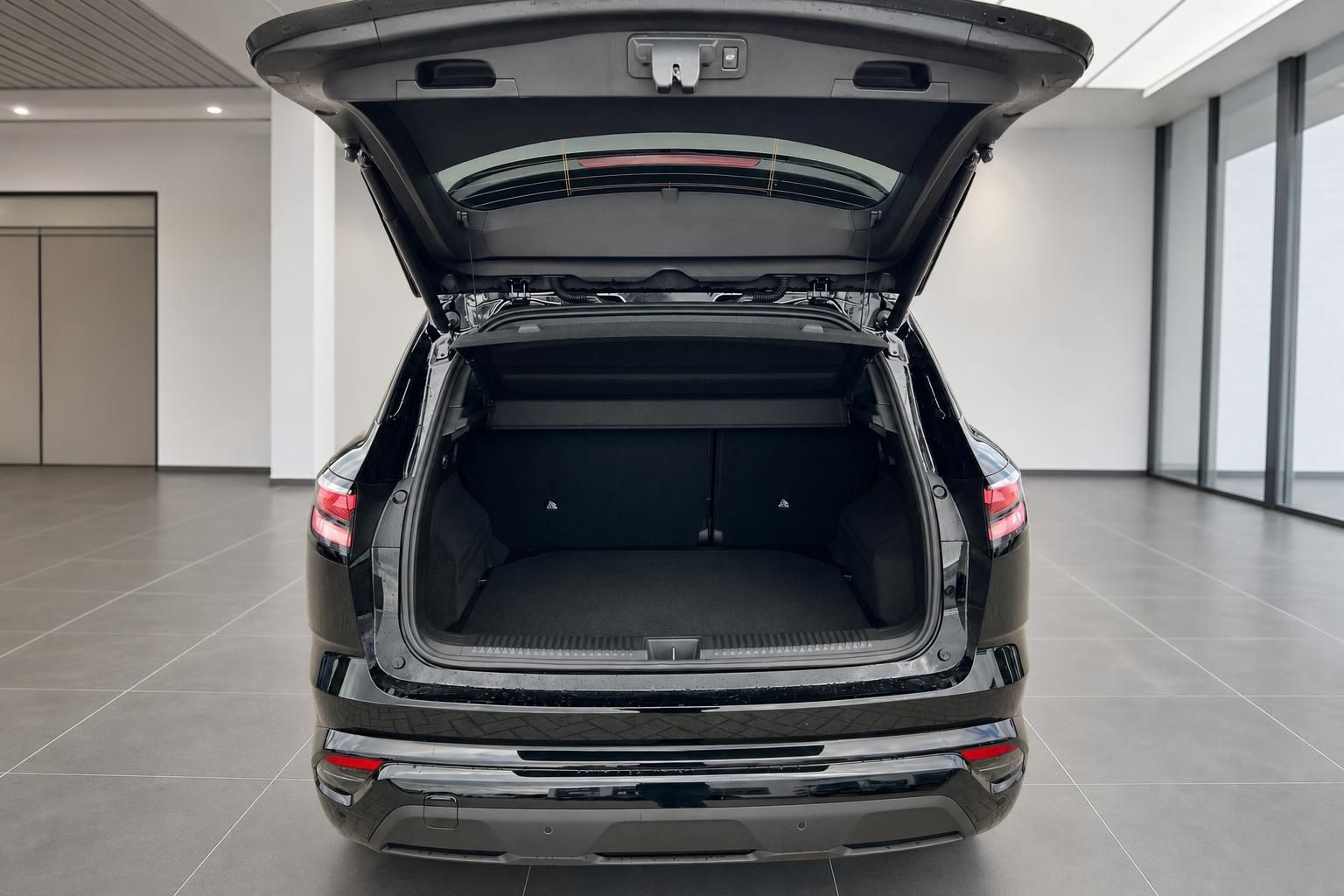 Kofferraum eines schwarzen SUV mit geoeffneter Heckklappe und viel Ladevolumen
