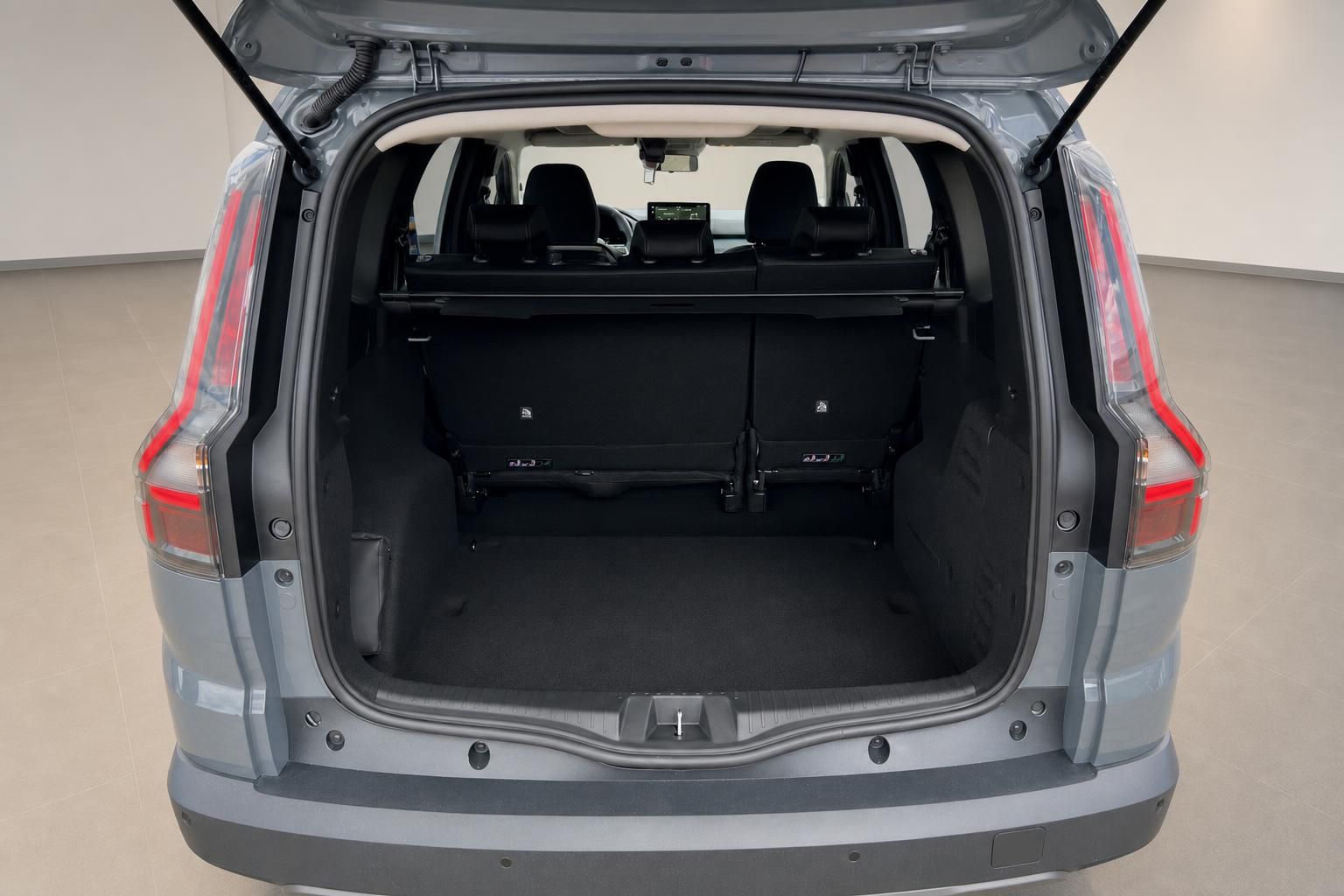 Kofferraum eines grauen SUVs mit geöffneter Heckklappe und umgeklappten Rücksitzen
