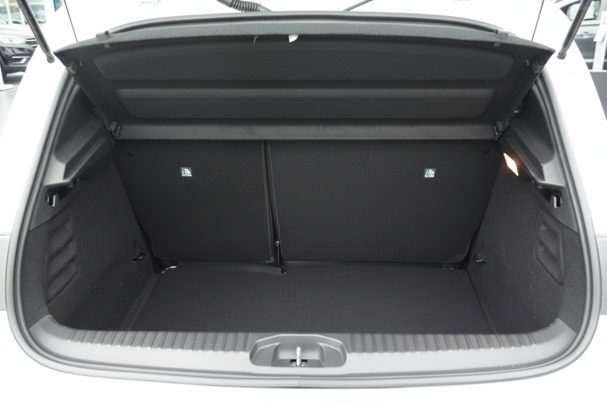 Geräumiger Kofferraum eines weißen Fahrzeugs mit umklappbarer Rücksitzlehne und schwarzer Auskleidung