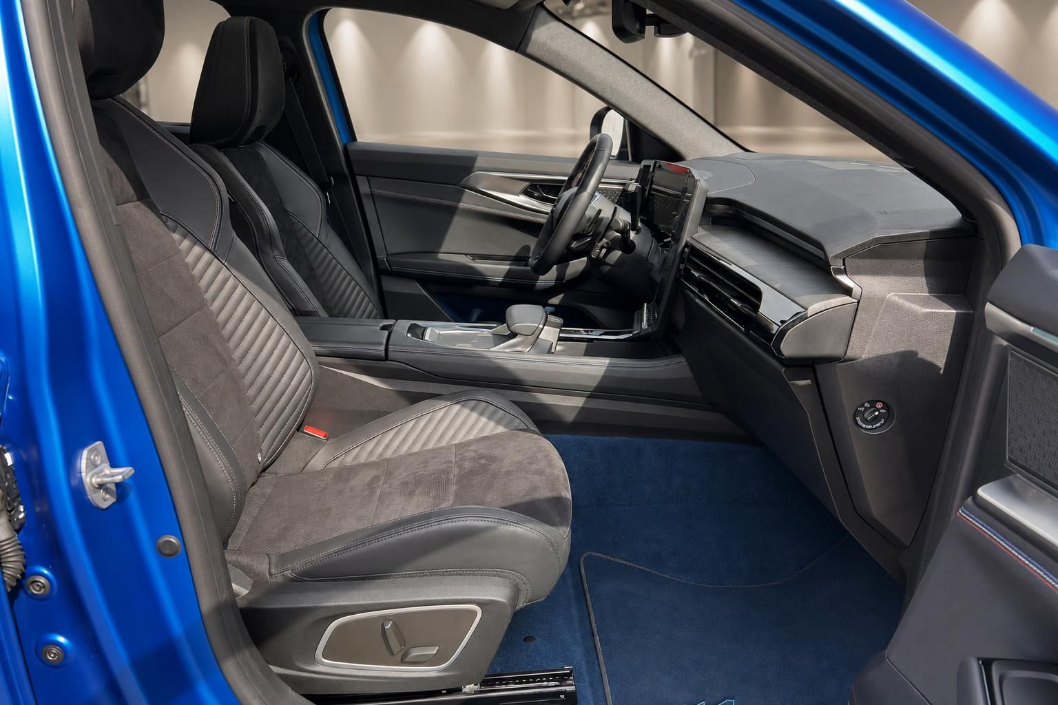 Fahrzeuginnenraum mit grauen Sitzen, Mittelkonsole und blauer Fußraumbeleuchtung
