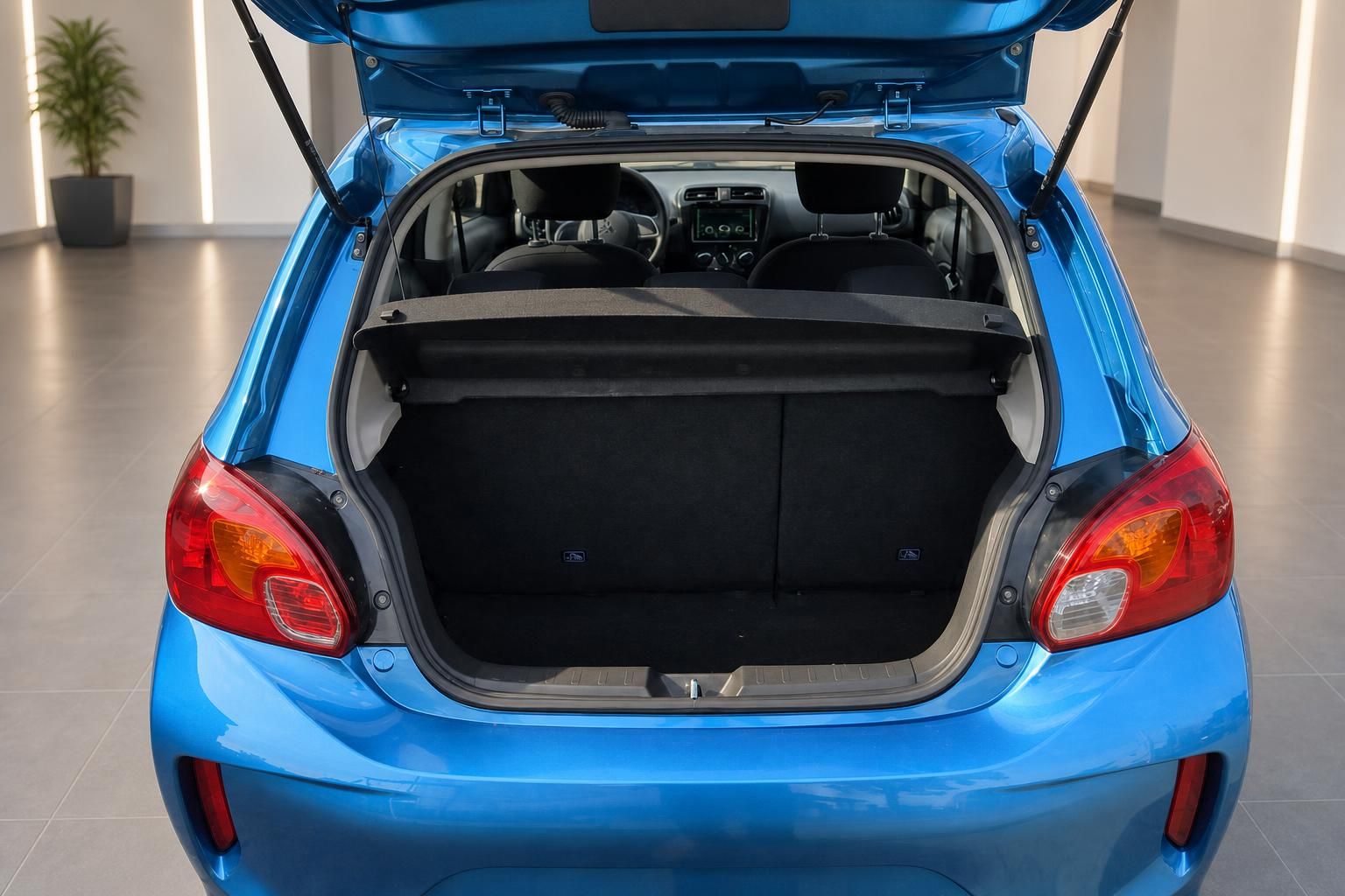 Blauer Kleinwagen Kofferraum offen zeigt Stauraum und schwarze Innenausstattung