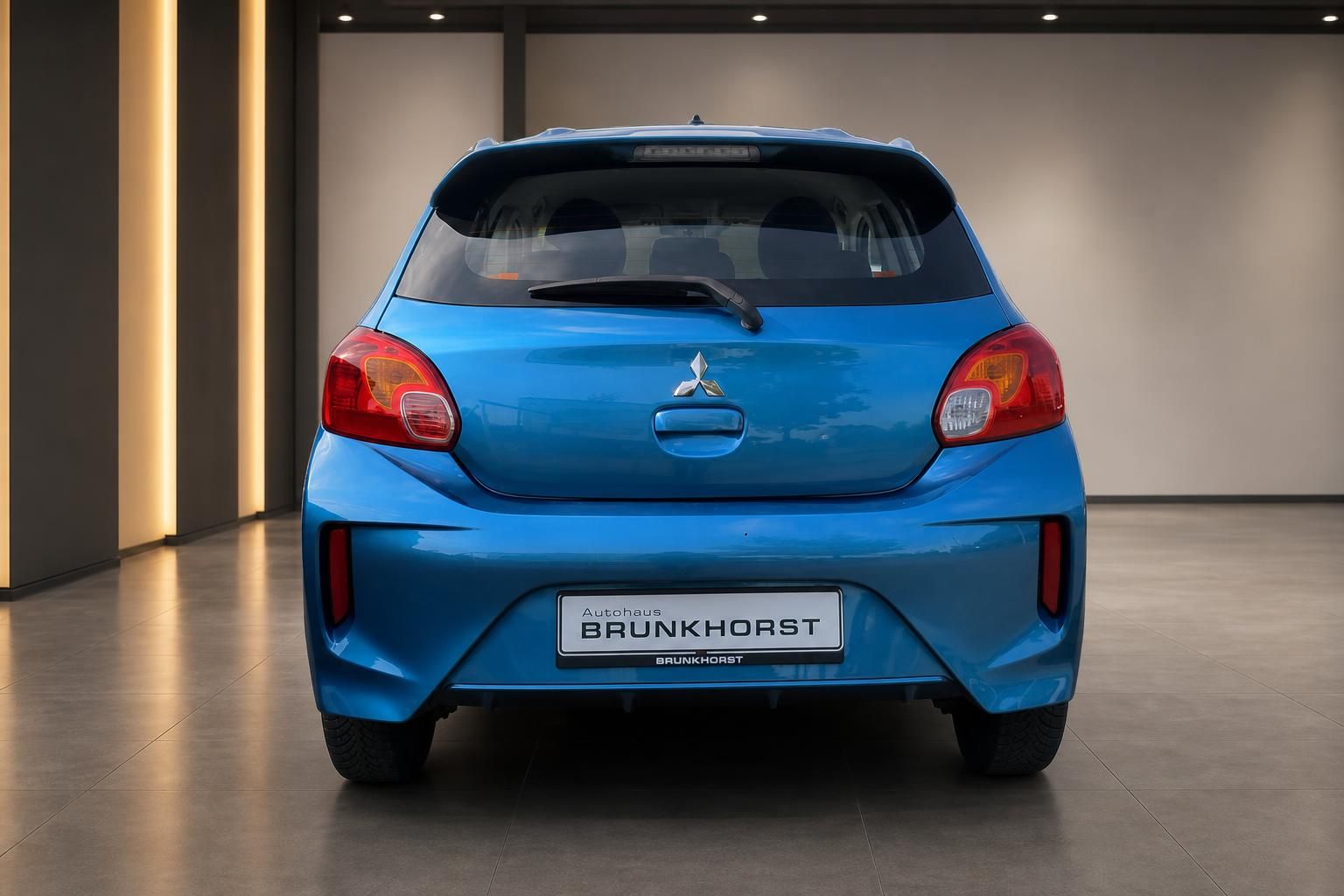 Blauer Mitsubishi Kleinwagen Heckansicht im modernen Autohaus mit LED-Beleuchtung