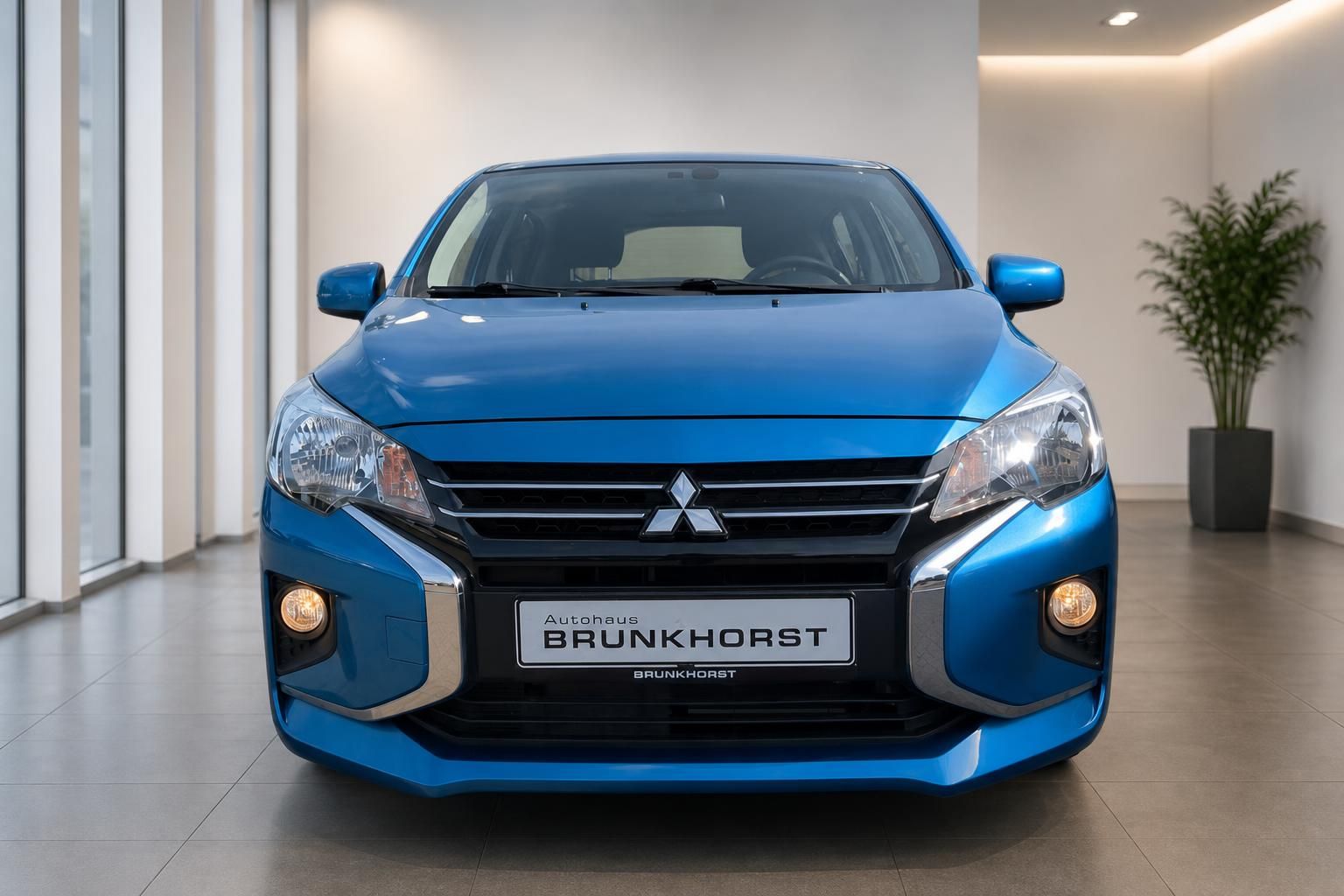 Blauer Mitsubishi Frontansicht mit Kühlergrill und Scheinwerfern im Autohaus Showroom