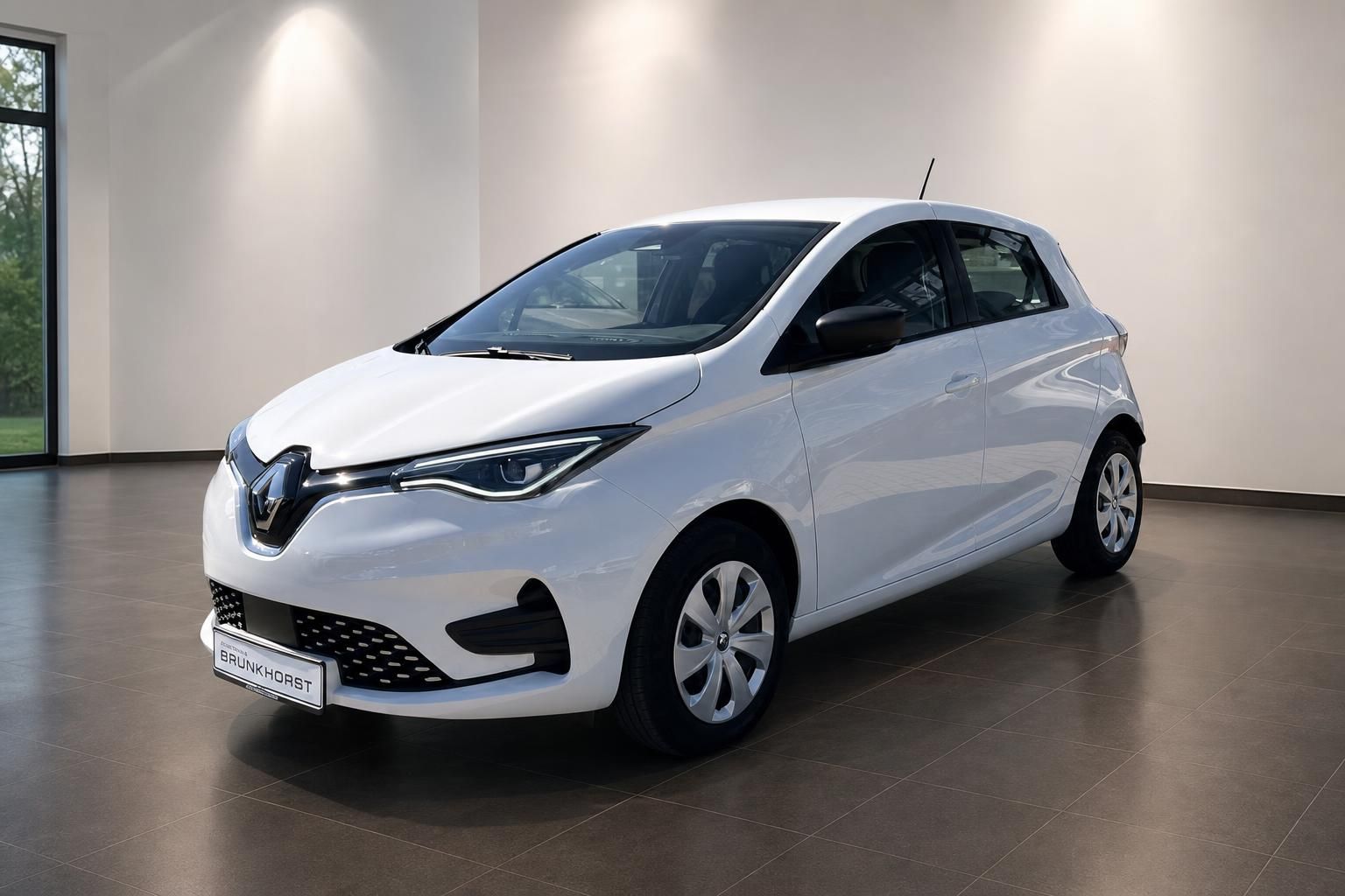 Weißer Renault ZOE Elektroauto Schrägansicht vorn im modernen Showroom - umweltfreundliches Elektrofahrzeug