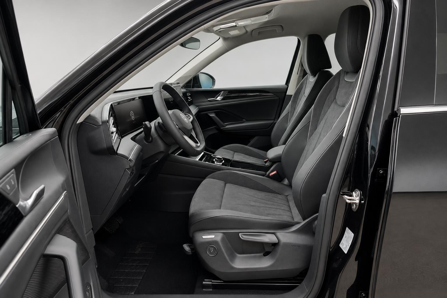 VW Innenraum mit Blick auf Vordersitze und geoeffnete Fahrertuer