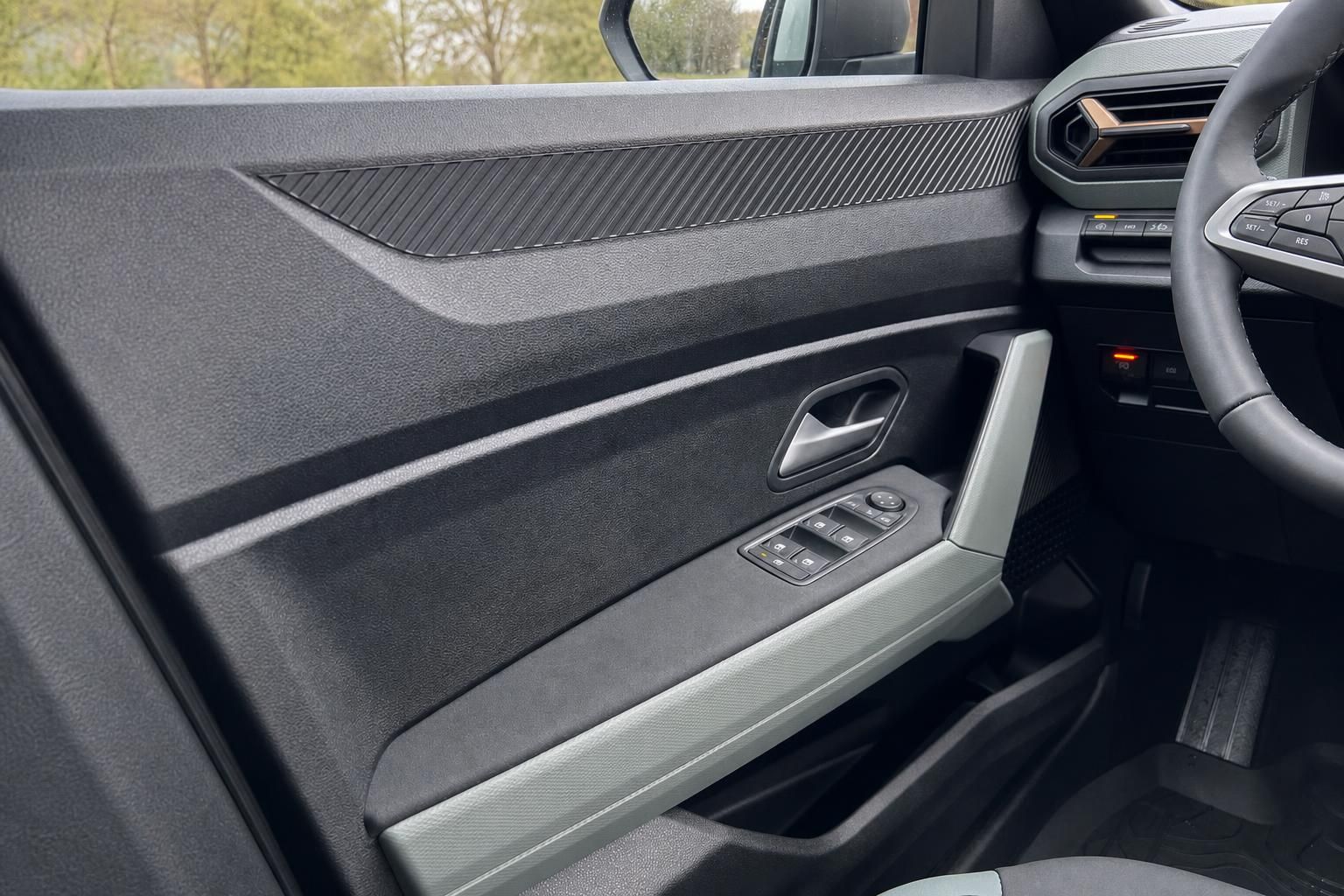 Fahrzeug Innenraum mit grauer Türverkleidung, Fensterheberschaltern und Carbon-Optik Einlagen