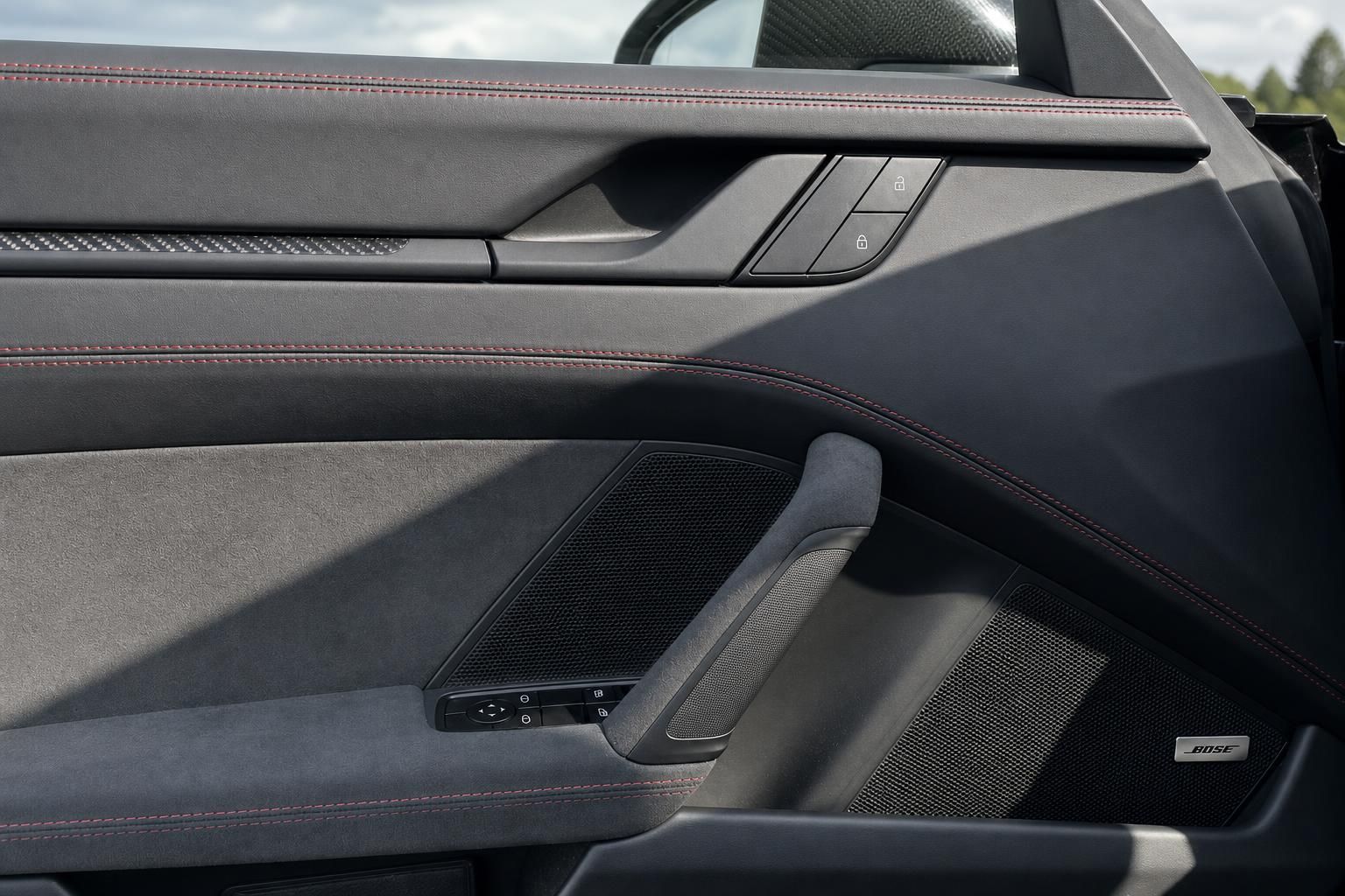 Porsche Türverkleidung mit roten Kontrastnähten, Lautsprecher und Carbon-Elementen