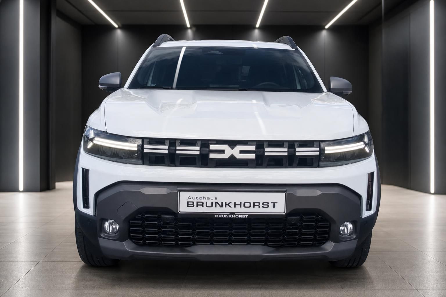 Dacia Duster weiß Frontansicht mit LED-Scheinwerfern im Showroom