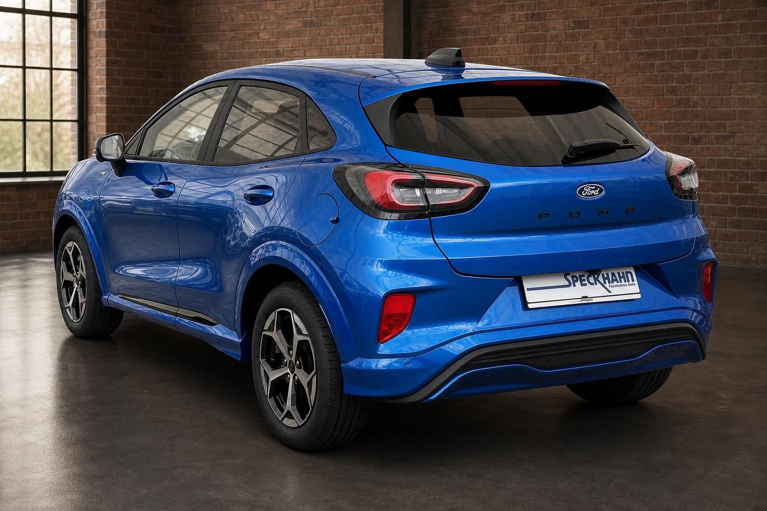 Ford Puma blau Heckansicht schraeg vor Backsteinmauer
