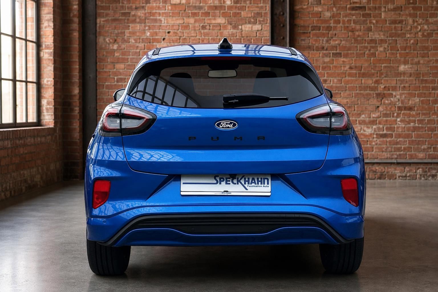 Ford Puma blau Heckansicht direkt in Industriehalle mit Ziegelwand