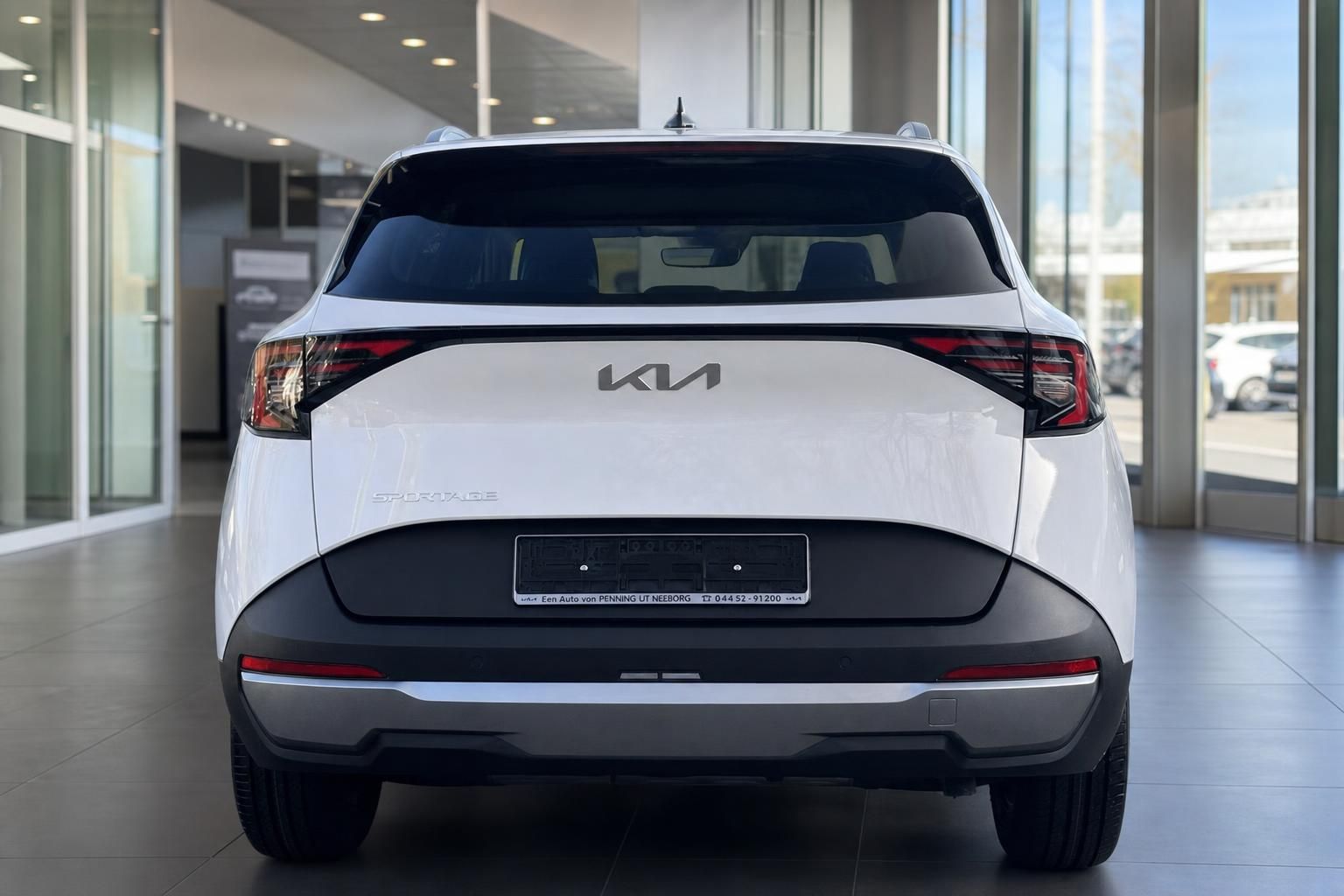 Kia Sportage weiß, Heckansicht mit Kia-Logo im Autohaus