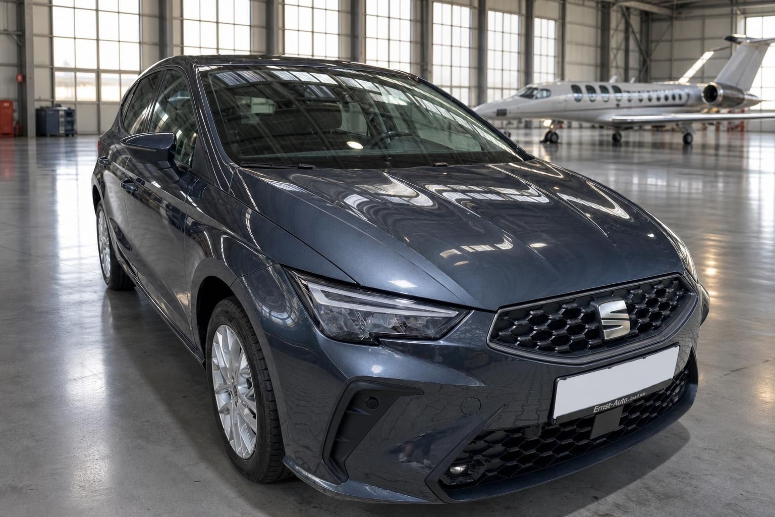 SEAT Ibiza grau metallic Frontansicht in Fahrzeughalle mit Flugzeug im Hintergrund