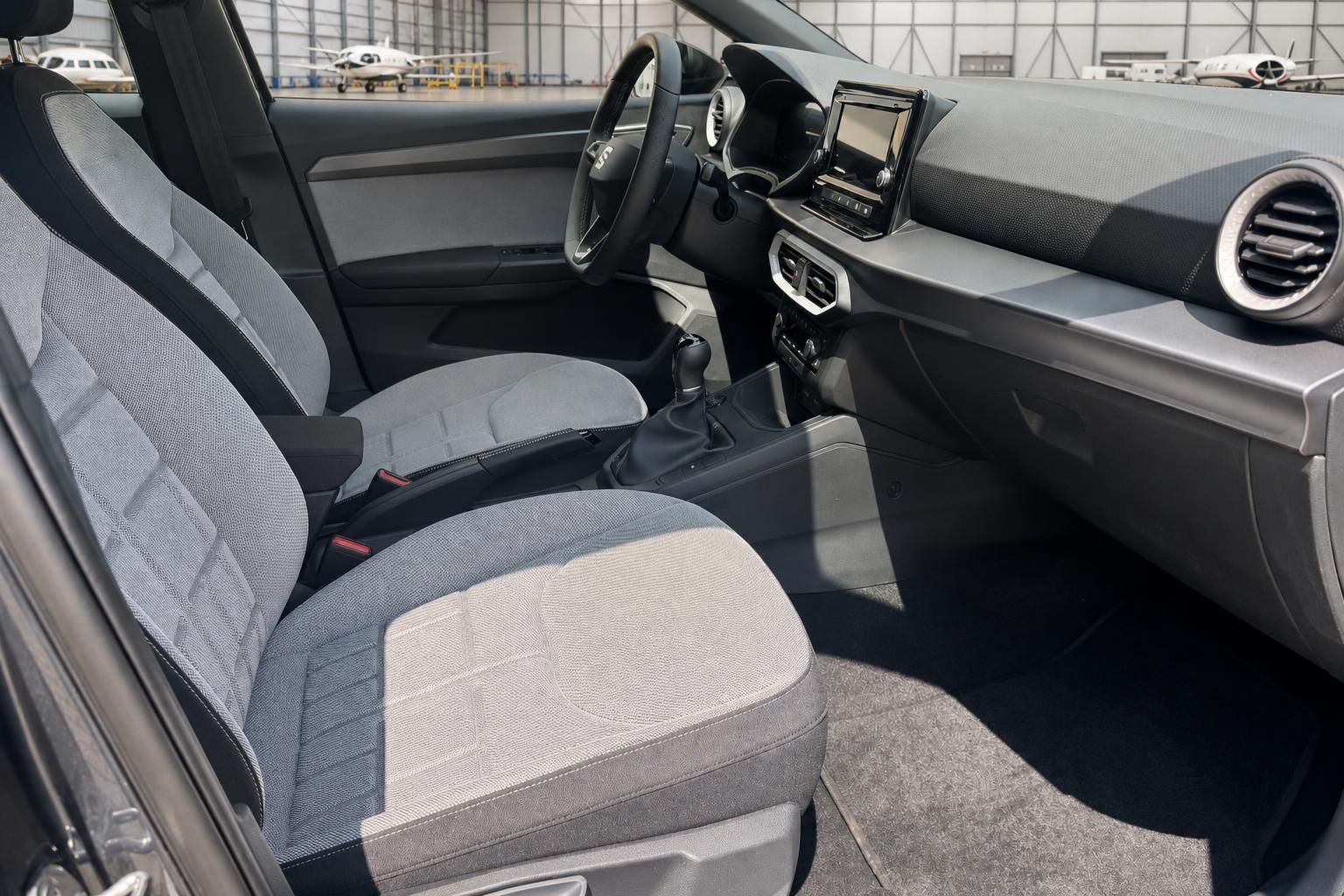 Innenraum-Ansicht mit Fahrersitz, Armaturenbrett und Infotainment-System