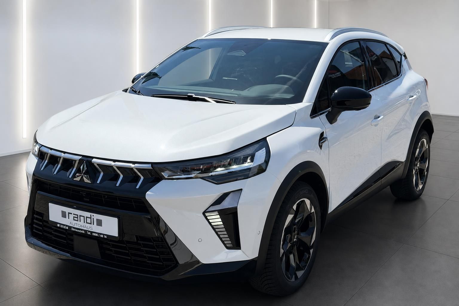 Mitsubishi SUV in Weiß, Frontansicht schräg im Autohaus-Showroom