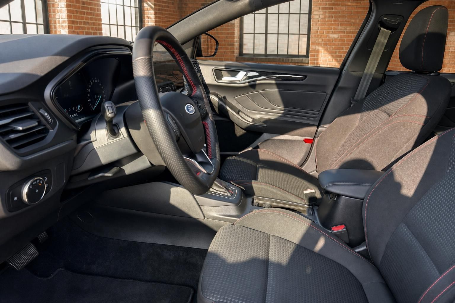 Ford Innenraum Vordersitze mit Sportlenkrad und roten Ziernaehten