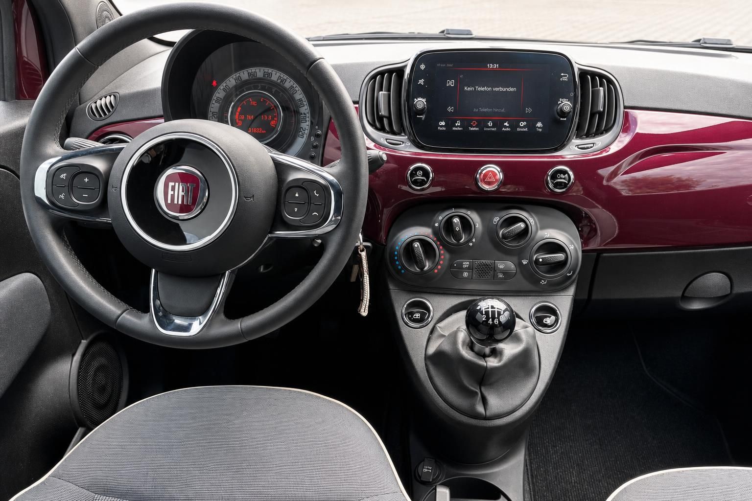 Fiat 500 Innenraum mit Cockpit, Lenkrad und Touchscreen in Bordeauxrot