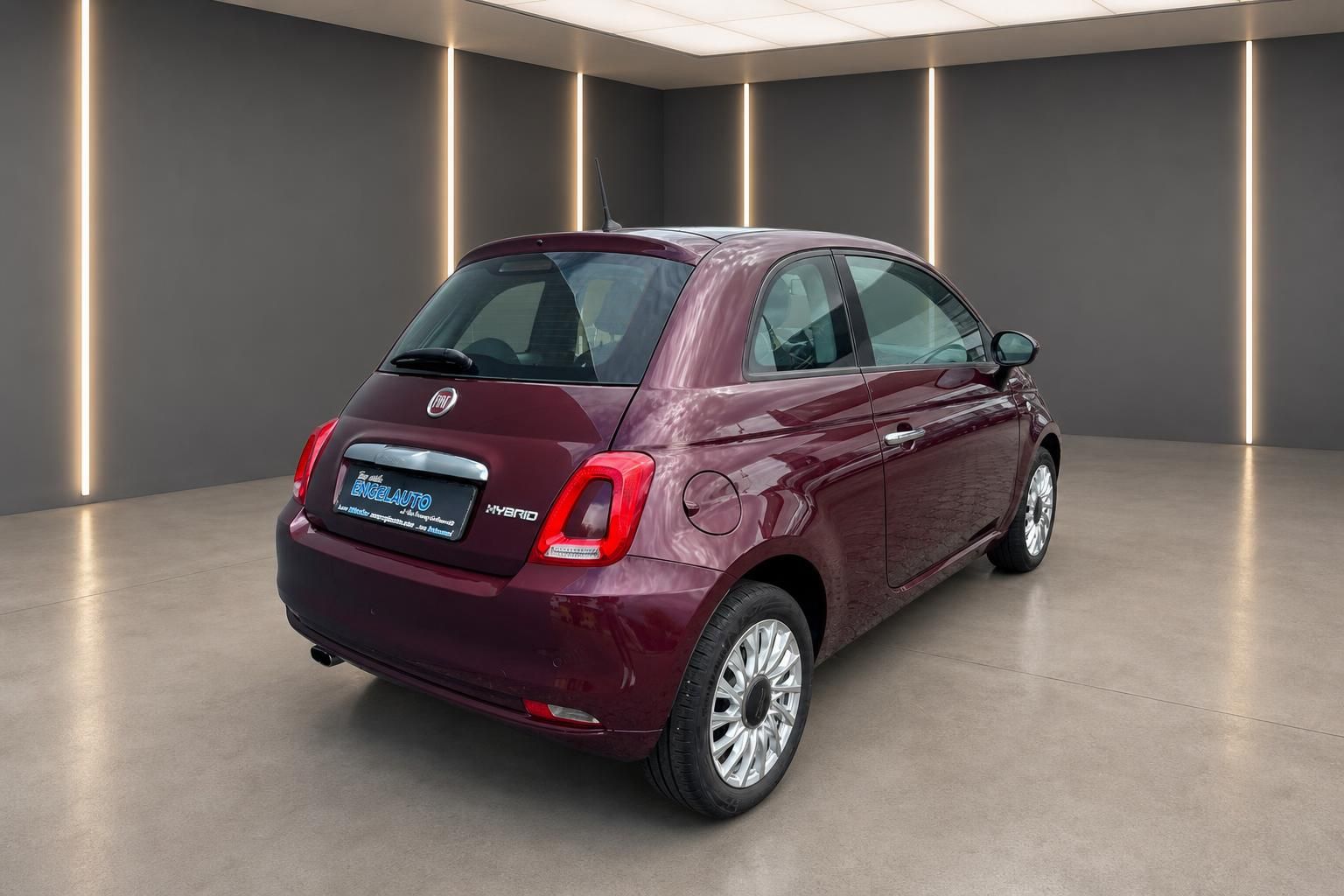 Fiat 500 Hybrid in Weinrot, Heckansicht schraeg im Showroom