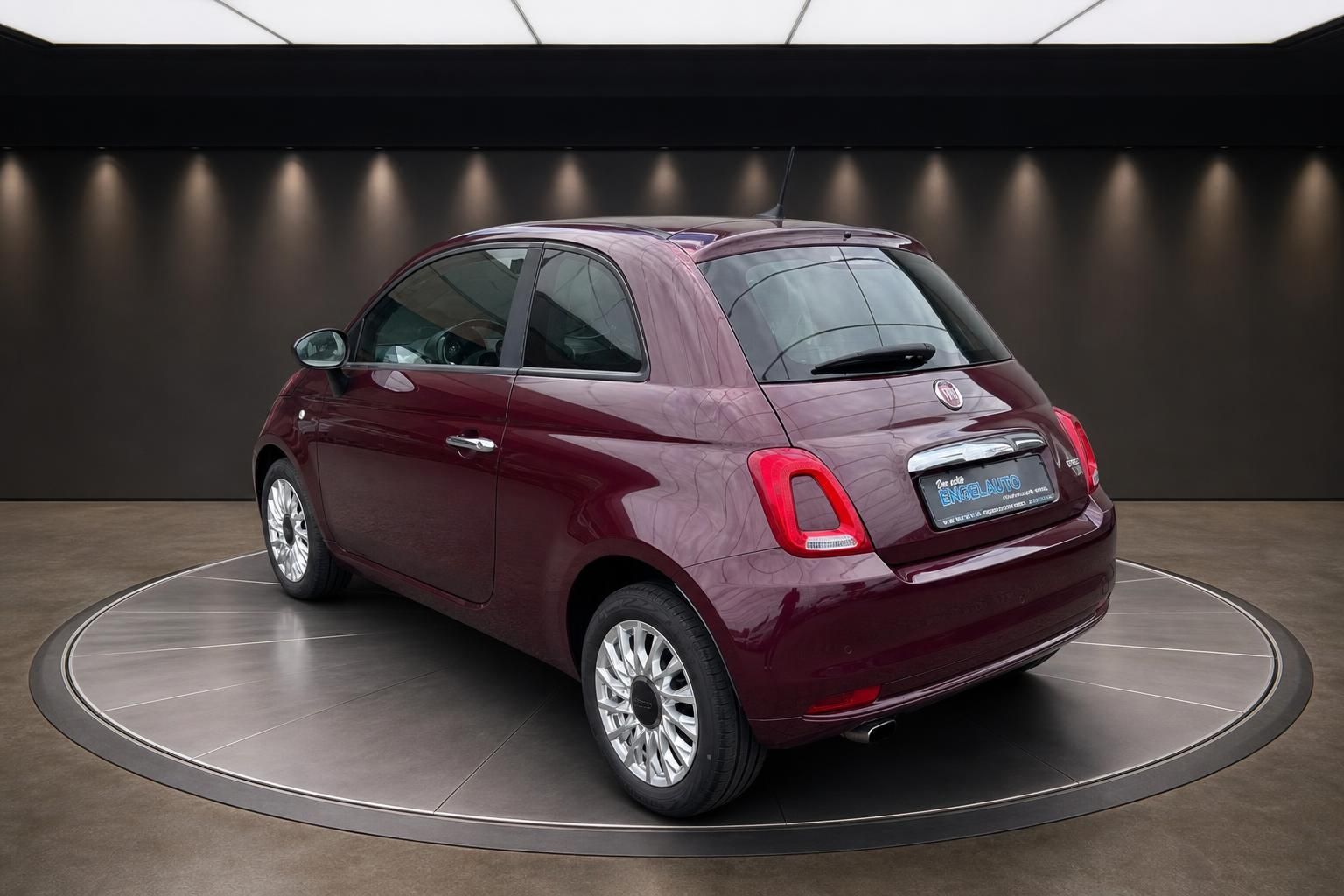 Fiat 500 in Bordeaux-Rot, Heckansicht schraeg auf Drehbuehne