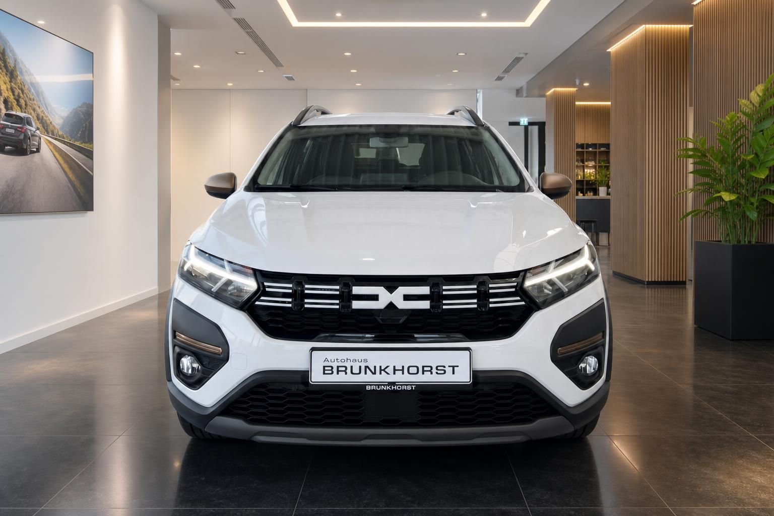 Weißer Dacia SUV Frontansicht im Autohaus Brunkhorst Showroom mit LED-Scheinwerfern