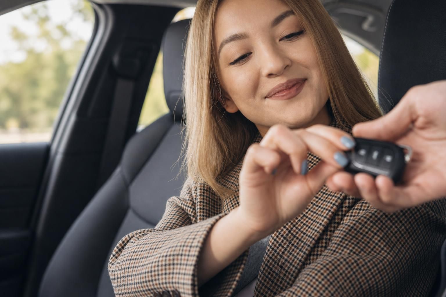 Frau mit Smartphone im Auto Innenraum - Beifahrersitz Perspektive