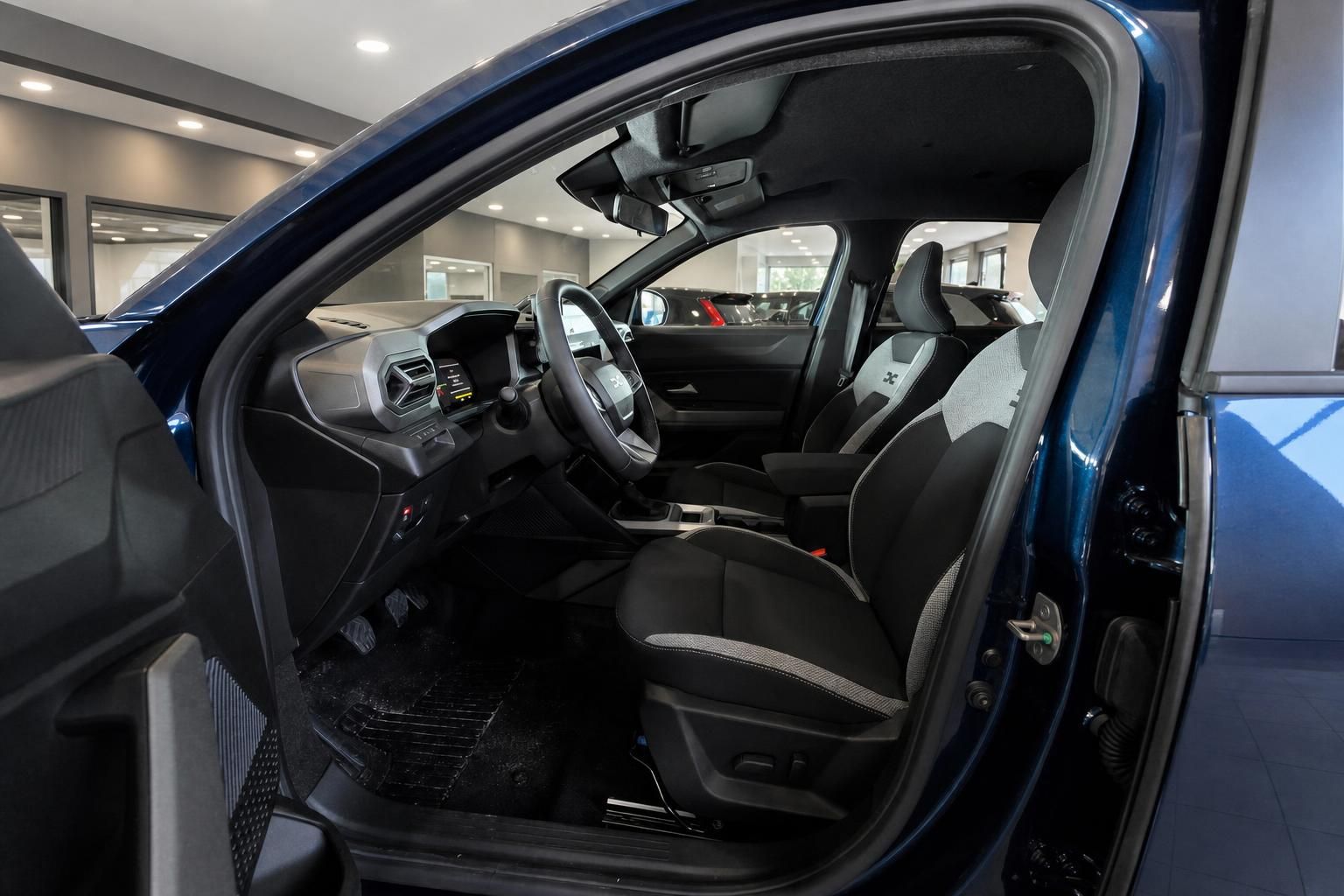 Innenraum eines blauen Dacia mit Sportsitzen und Cockpit im Autohaus