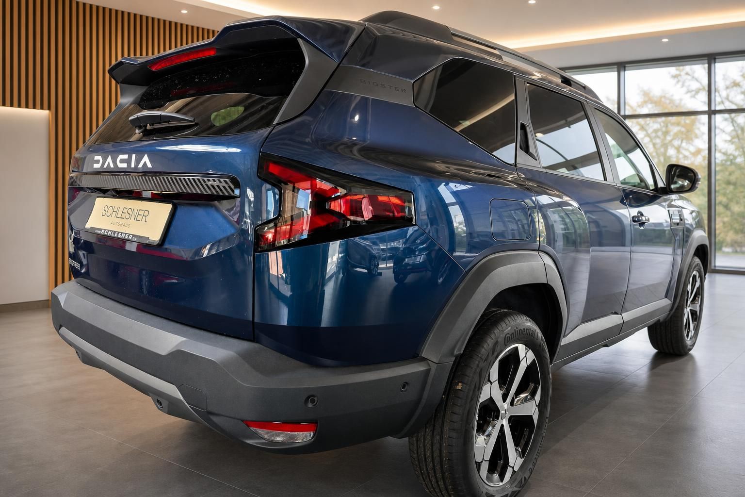 Dacia Bigster blau Heckansicht im Showroom mit Felgen