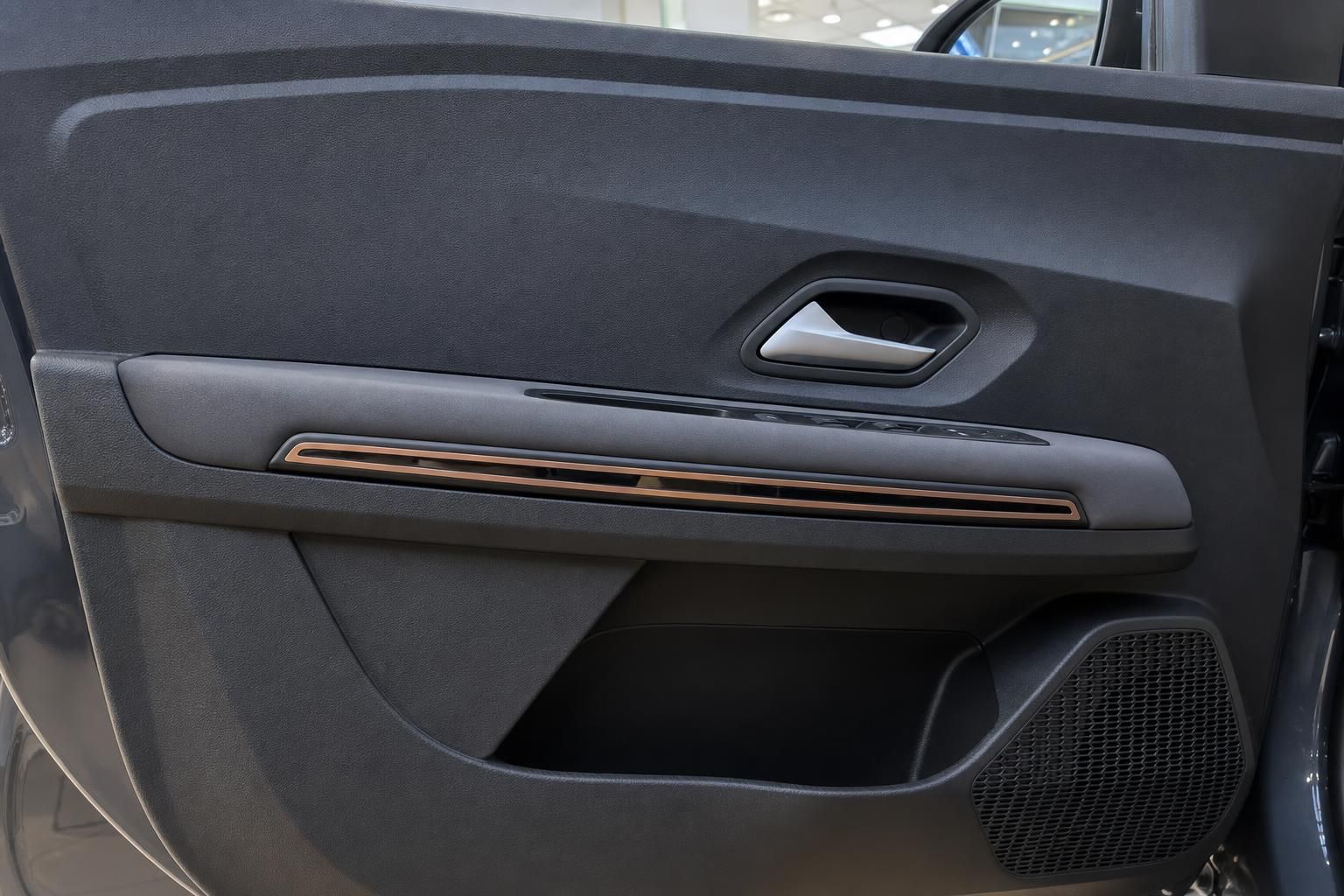 Türverkleidung mit Kupferdetails und Lautsprecher im Fahrzeuginnenraum