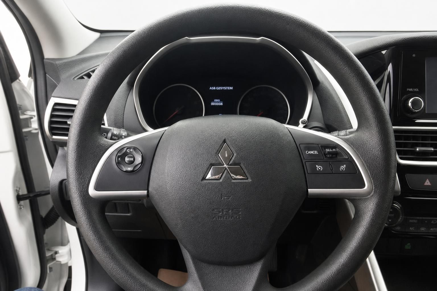 Mitsubishi Lenkrad mit Multifunktionstasten, Tachometer und Infotainment-Display im Hintergrund