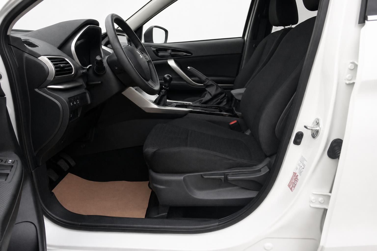 Mitsubishi Innenraum Fahrerseite mit schwarzen Stoffsitzen, Mittelkonsole und geöffneter Tür