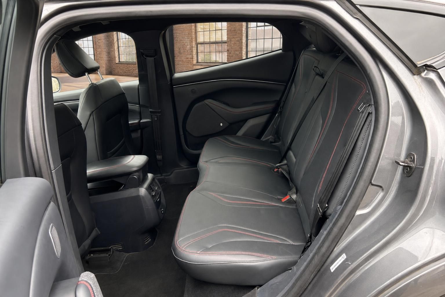 Ford Mustang Mach-E Rueckbank mit schwarzem Lederinterieur und roten Ziernaehten