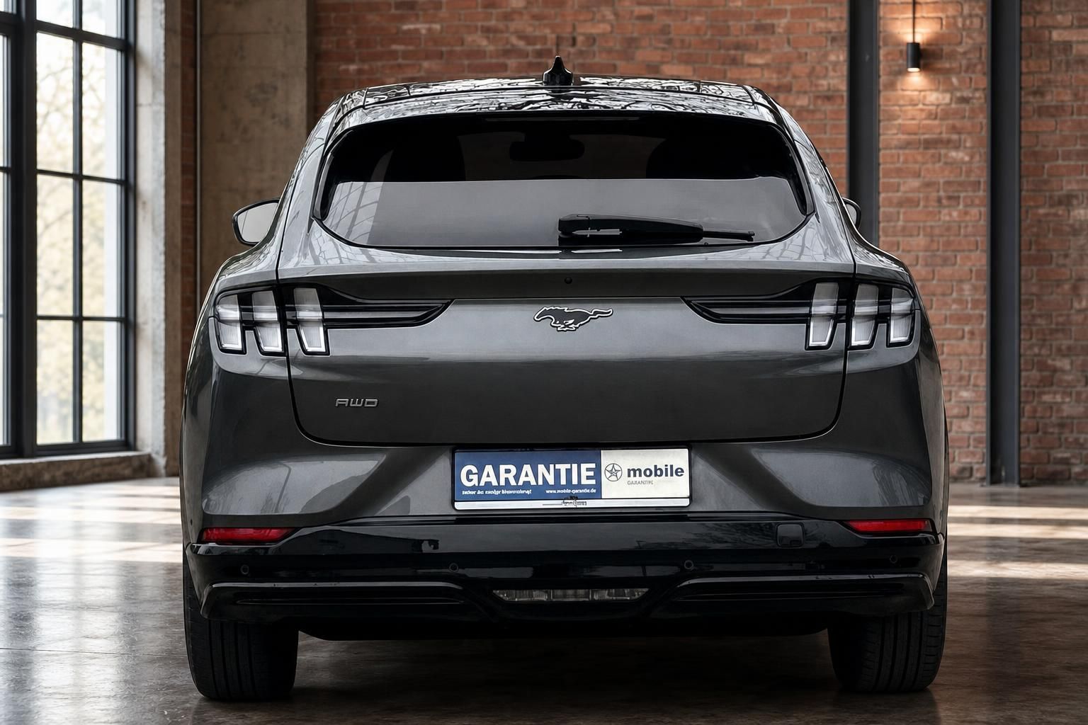 Ford Mustang Mach-E Grau, direkte Heckansicht mit Rueckleuchten