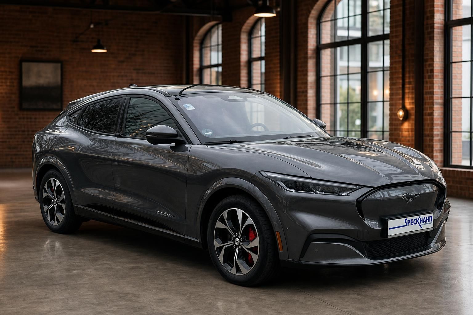 Ford Mustang Mach-E Grau, Frontansicht seitlich im Showroom