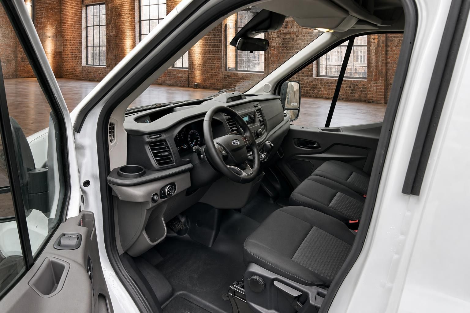 Ford Transit Innenraum – Cockpit mit Lenkrad, Armaturenbrett und schwarzen Stoffsitzen