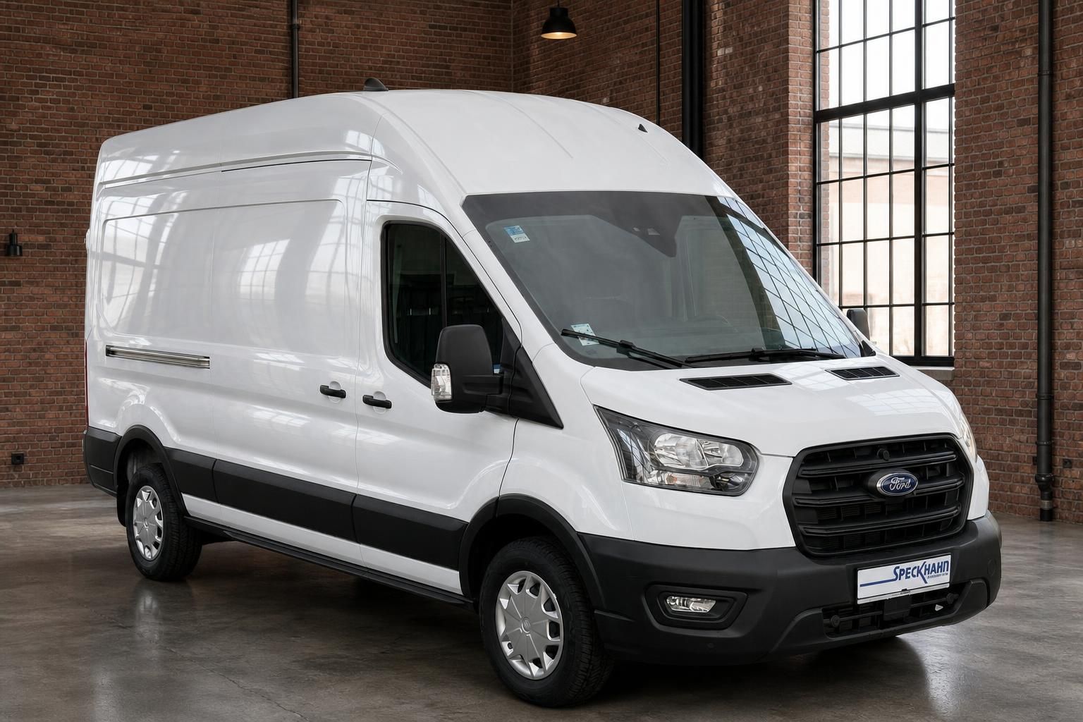 Ford Transit Kasten weiß Frontansicht schräg links – Hochdach Transporter im Industriegebäude
