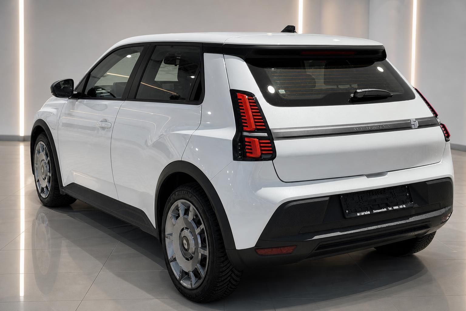Renault 5 E-Tech in Weiss, Heckperspektive schraeg im Autohaus
