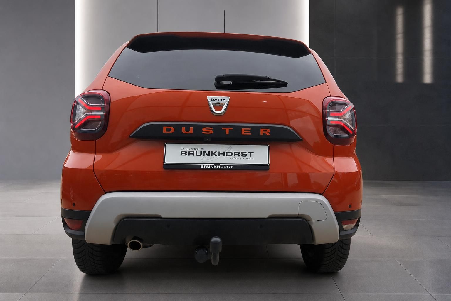 Dacia Duster orange Heckansicht mit DUSTER-Schriftzug und Brunkhorst Kennzeichen