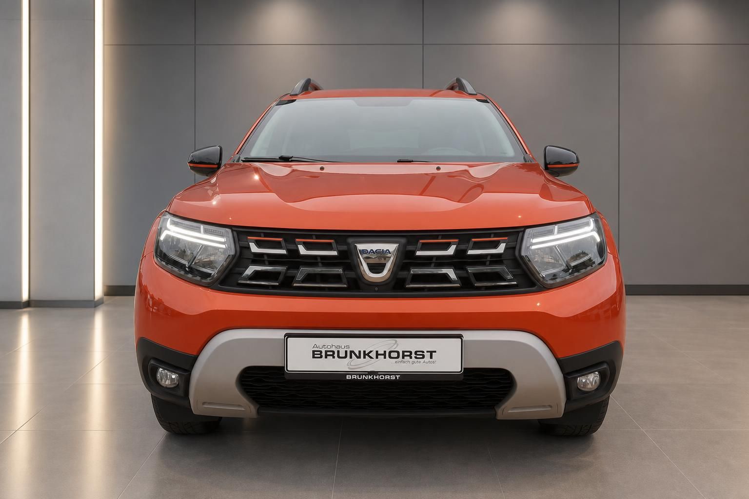 Dacia Duster orange Frontansicht mit LED-Scheinwerfern und Brunkhorst Kennzeichen