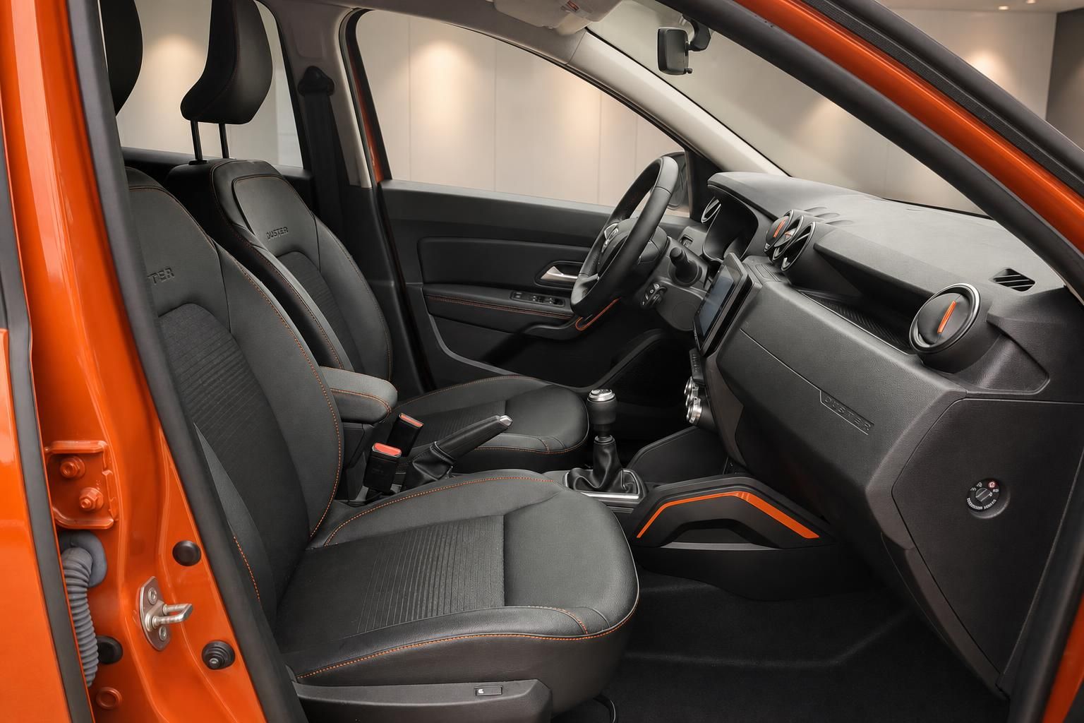 Fahrzeuginnenraum mit Fahrer- und Beifahrersitz, Schaltknauf und orangenen Designelementen