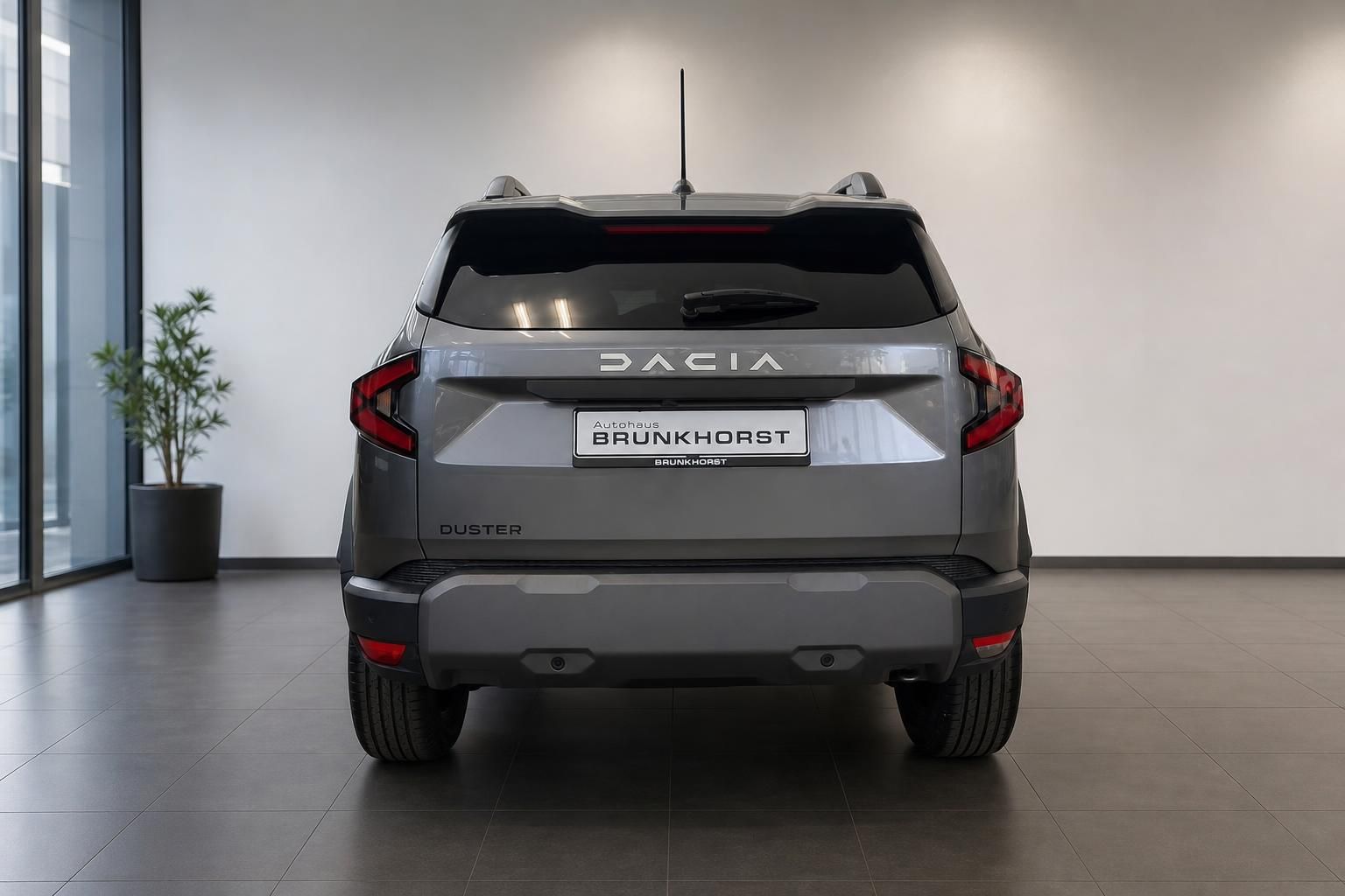 Dacia Duster Heckansicht in grau mit modernen LED-Rückleuchten im Showroom