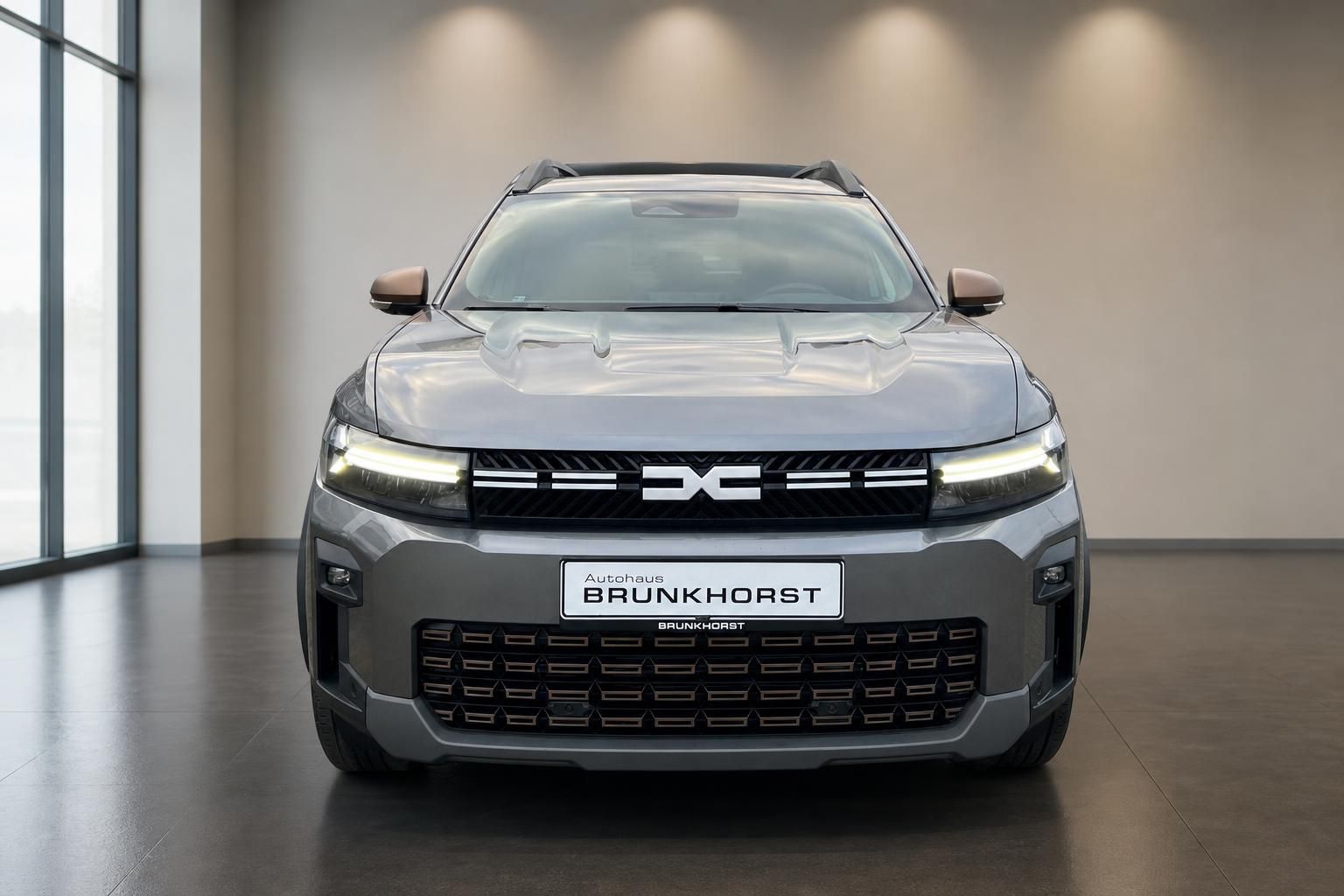 Dacia SUV Frontansicht in silbergrau im modernen Autohaus Brunkhorst Showroom