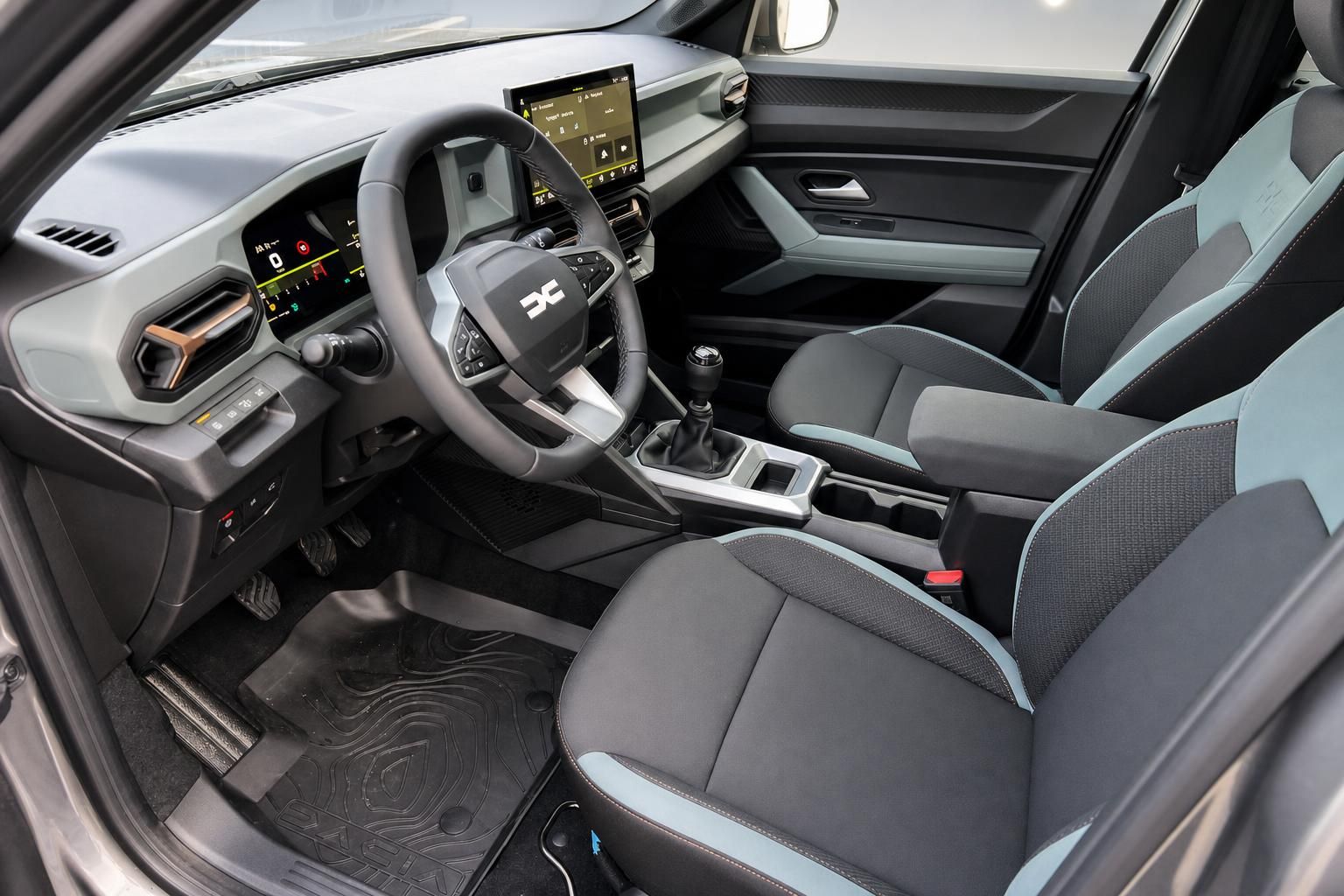 Dacia Innenraum mit modernem Cockpit, Touchscreen und grauen Sitzen mit blauen Akzenten