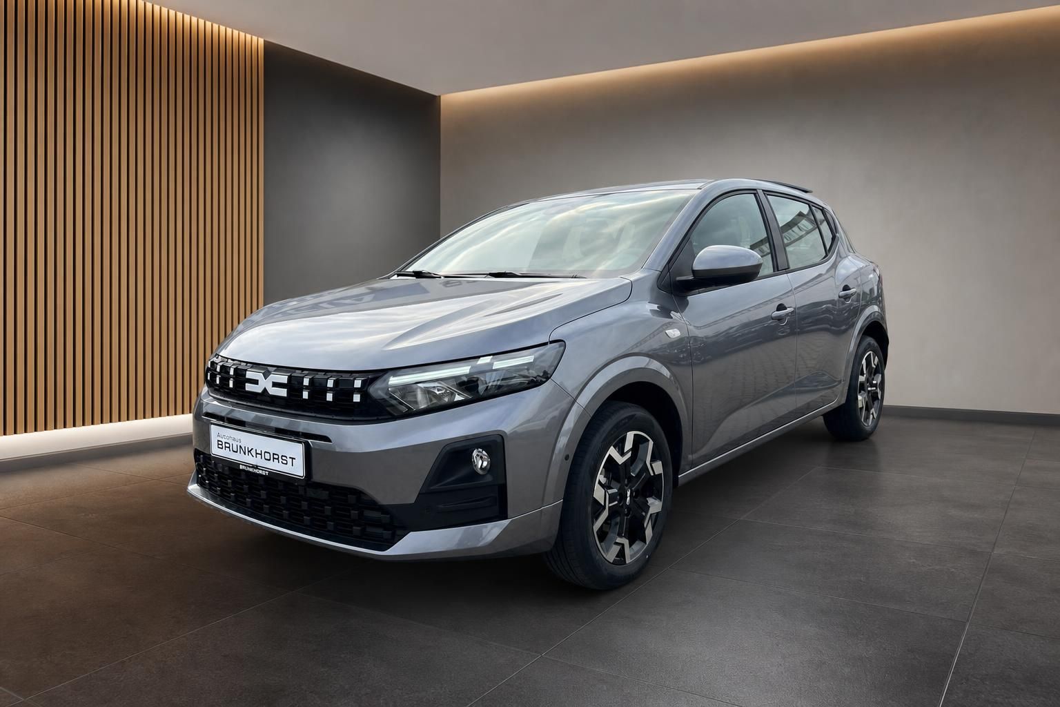 Dacia Sandero grauer Kompaktwagen Frontansicht im modernen Autohaus Showroom