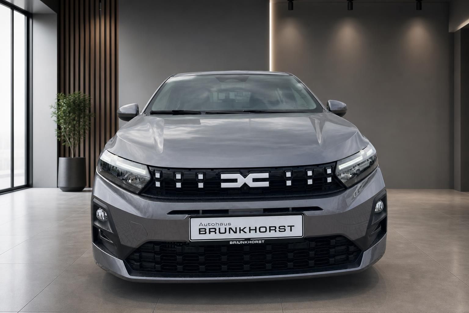 Dacia Fahrzeug Frontgrill mit Logo und Autohaus Brunkhorst Kennzeichenhalter grau