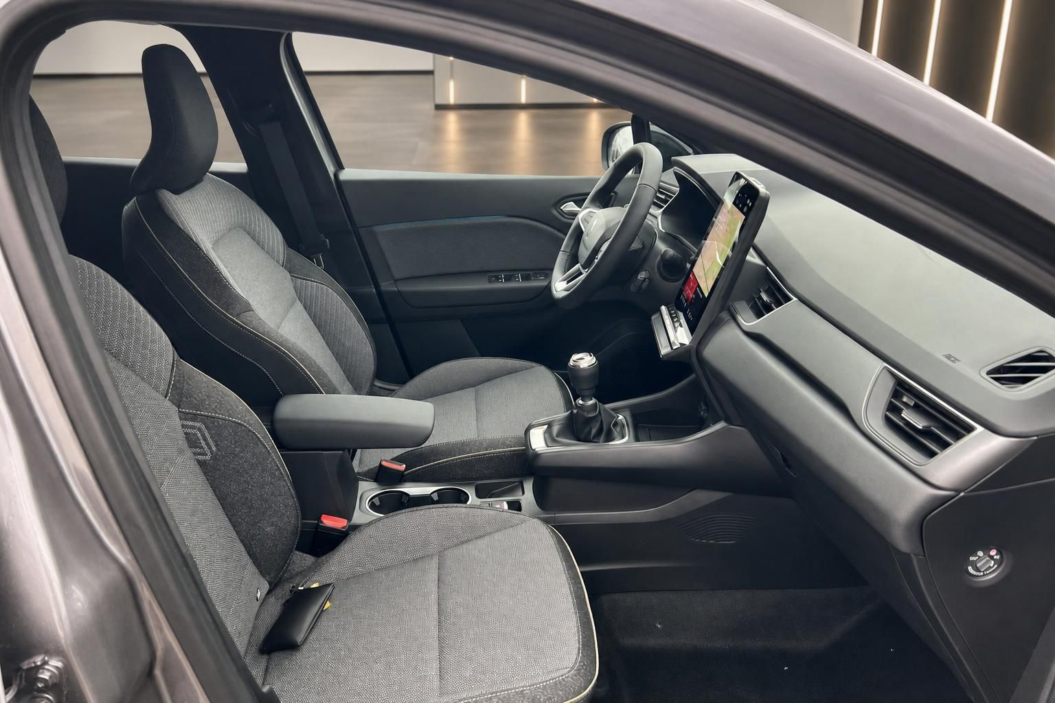 Renault Captur Fahrerplatz mit Lenkrad, Armaturenbrett und Mittelkonsole in grau